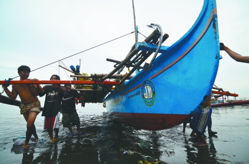 當(dāng)?shù)貢r間8月10日，馬尼拉海域，漏油事故附近居民開始清理海灘上的油污